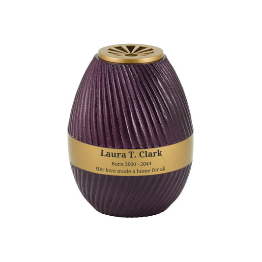 Violet-finish aluminum and brass tall cylindrical scattering urn with sunray pattern upright on white background