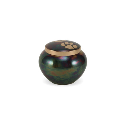Metal pet urn with an iridescent green and purple body, a golden lid, and a prominent paw print design