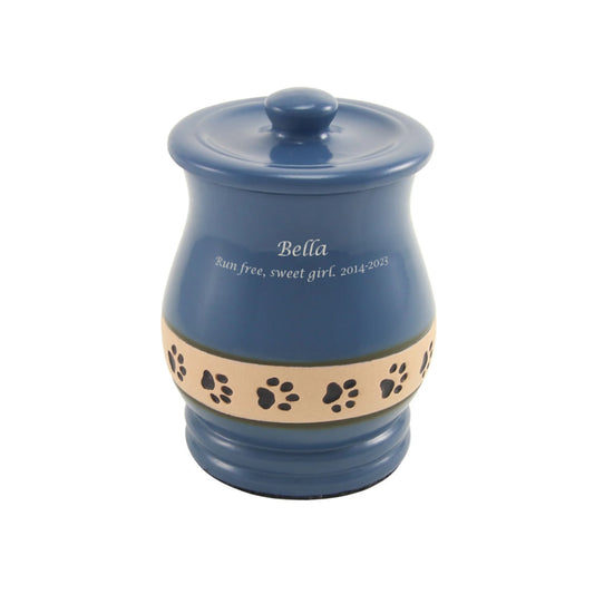 Blue ceramic cremation urn with paw print design front view on white background, straight front view