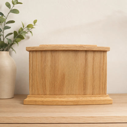 Oak wood memorial box shown from the rear in a home setting with removable storage panel